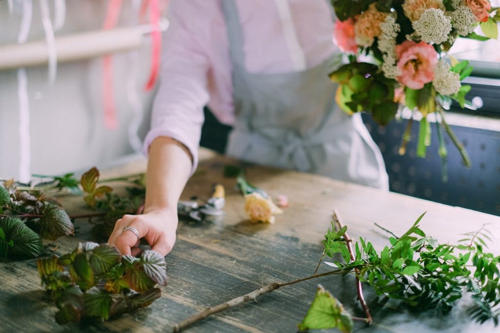 Fiorista che prepara composizione di fiori funebri Milano